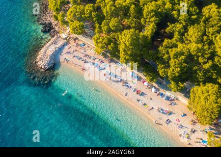 Vista aerea della spiaggia di sabbia fine attrezzata con ombrelloni colorati, mare azzurro mare Foto Stock