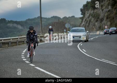 Auto il sorpasso di due ciclisti su una curva della strada Islares Cantabria, Spagna, Europa Foto Stock