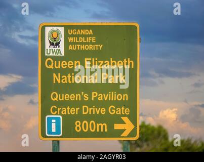 Un cartello stradale segnando l'ingresso al Queen Elizabeth National Park, una popolare destinazione di safari in Africa orientale. Foto Stock
