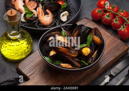 Le cozze in salsa di pomodoro e le foglie di basilico e piatti di pasta Foto Stock