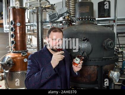 16 dicembre 2019, Sassonia-Anhalt, Zeitz: Daniel Rost, mastro distillatore e proprietario dell'impresa Zeitzer Whisky fabbricazione; prove un whisky. Nella manifattura è il più antico whisky ancora in Germania (a destra nell'immagine) dal 1935, dall'ingegneria meccanica azienda Golzern-Grimma. Ora l'apparecchio è il cuore dell'impresa Zeitzer manufactory. Esso è stato utilizzato per la prima volta nel 1950 in Luckenwalde, Brandeburgo, dalla società C.W. Falckenthal Söhne. A partire dal mese di aprile, la storica ancora è stato acceso nuovamente parecchie volte al mese. Circa 22000 litri di alcole puro brucia la ruggine per anno a Zeitz. Nuovo barili sono reg Foto Stock