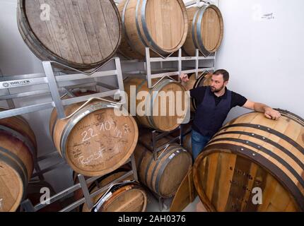 16 dicembre 2019, Sassonia-Anhalt, Zeitz: Daniel Rost, mastro distillatore e proprietario dell'impresa Zeitzer Whisky Manufaktur è in piedi nella sua botte store. Circa 22.000 litri di alcole puro brucia la ruggine per anno a Zeitz. Nuovo barili vengono aggiunti regolarmente al magazzino e un massimo di un barile al mese viene imbottigliato. In questo momento i tre e i cinque anni di whisky è disponibile. La domanda è aumentata significativamente prima di Natale, dice il chimico addestrato. Secondo l'Associazione tedesca delle distillerie di whisky, la quota di mercato di lingua tedesca il whisky è 0,4%. Ci sono attualmente 210 whisky distille Foto Stock