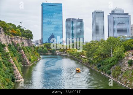 La vista lungo la superficie interna fossato del castello di Osaka con l'Osaka Business Park sullo sfondo. Osaka. Giappone Foto Stock