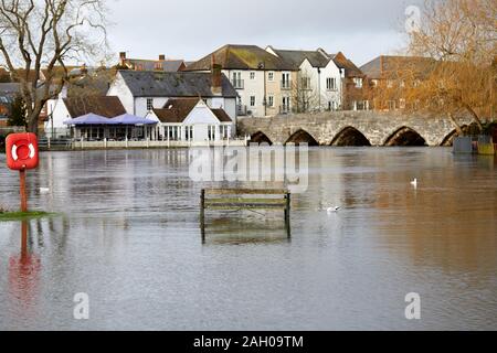 Fordingbridge, Hampshire - Dic 22, 2019: su una panchina del parco a filamento si siede in acqua allagata dopo il fiume Avon scoppiare le sue banche in seguito a un periodo di intensa pioggia. Foto Stock