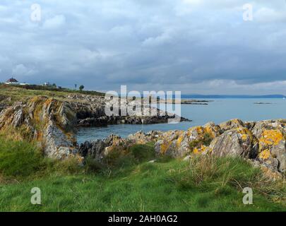 Una vista attraverso la bocca del Belfast Lough dal punto Orlock a Groomsport verso Blackhead nella contea di Antrim su una calma nuvoloso pomeriggio d'autunno. Foto Stock