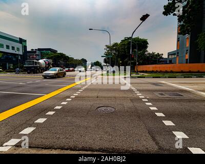 Ampio angolo di visione di un attraversamento pedonale / strada che attraversa in Singapore in una giornata di sole Foto Stock