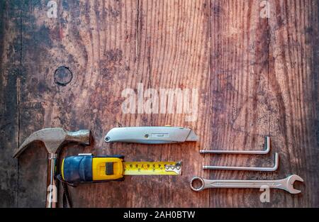 Vista dall'alto in basso di vari strumenti per il fai da te su un sfondo di legno con copia spazio sopra Foto Stock