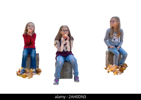 I bambini mangiano le mele mentre è seduto sul cemento di monconi in autunno, isolato su sfondo bianco Foto Stock