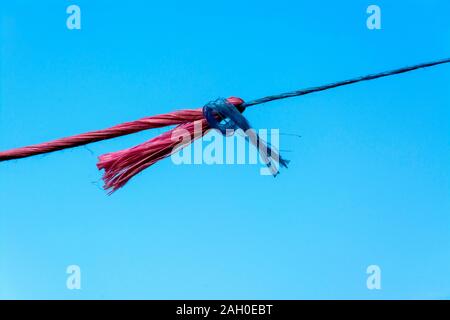 Primo piano di corde rosse e blu sotto la luce del sole contro un cielo blu durante il giorno Foto Stock