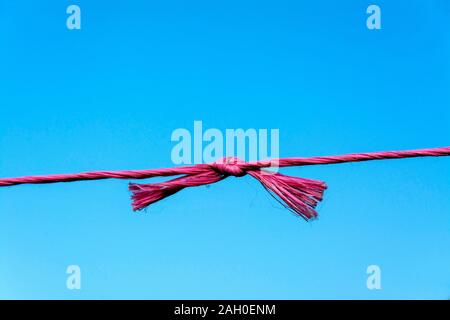 Primo piano di corde rosse e blu sotto la luce del sole contro un cielo blu durante il giorno Foto Stock