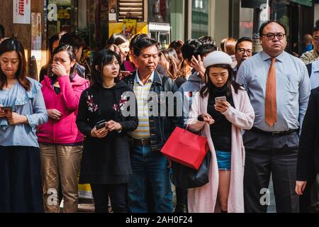 HongKong - Novembre 2019: gruppo di persone in attesa sul semaforo attraversare la strada in HongKong city, il quartiere centrale degli affari. Foto Stock