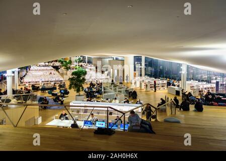 Finlandia, Helsinki - Dicembre 10, 2019: Helsinki Biblioteca Centrale Oodi - biblioteca moderna. Interno, di lettura e di lavoro persone Foto Stock