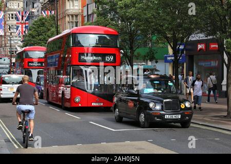 LONDON, Regno Unito - 7 Luglio 2016: la gente ride nuovi autobus Routemaster in Oxford Street, Londra. L'ibrido diesel-elettrico di bus è una nuova e moderna versione di icona Foto Stock