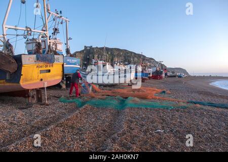 Hastings, East Sussex, Regno Unito. Il 23 dicembre 2019. Hastings fisherman ordina le sue reti di sunrise su un soleggiato e mite giorno di dicembre. Carolyn Clarke/Alamy Live News Foto Stock