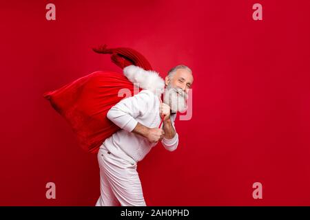 Hipster senior l uomo moderno santa a parte portare presenta moda indossando vestiti a maglia isolato sfondo rosso Foto Stock
