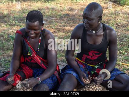 Ritratto di tribù Mundari donne con scarifications sulla fronte la preparazione di arachidi, Equatoria centrale, Terekeka, sud Sudan Foto Stock