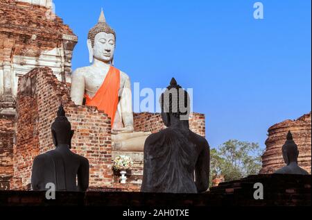 Statue di Buddha in un antico tempio buddista su uno sfondo di cielo blu Foto Stock