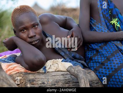 Ritratto di una tribù Mundari donne appoggiato su un letto di Equatoria centrale, Terekeka, sud Sudan Foto Stock