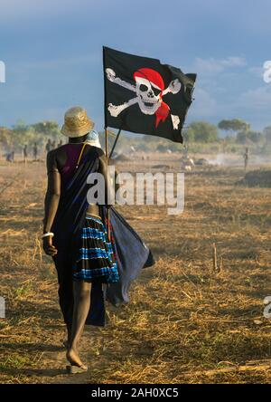 Tribù Mundari donne marciando in linea con una bandiera pirata durante la celebrazione di un matrimonio di Equatoria centrale, Terekeka, sud Sudan Foto Stock