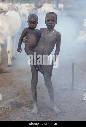 Tribù Mundari boys coperto di cenere avendo cura di lunghe corna di mucche in un accampamento di Equatoria centrale, Terekeka, sud Sudan Foto Stock