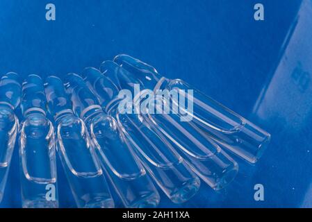 Medico di vetro fiala fiala per iniezione. La medicina è liquido cloruro di sodio con di soluzione acquosa in ampolla. Close up. Bottiglie ampolla multicolore. Foto Stock