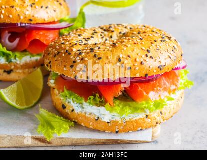 Bagel con formaggio, pesce rosso, cipolla e lattuga. Foto Stock