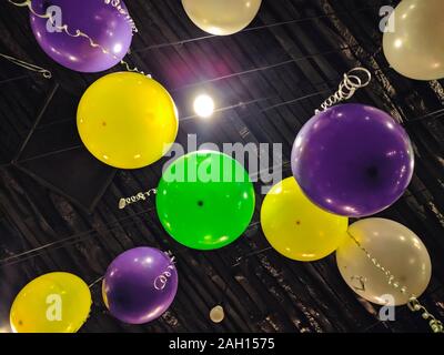 Palloncini colorati in camera oscura.palle e palloncini in camera decorata per la festa di compleanno di appendere al di sotto del soffitto nero.tono scuro Foto Stock