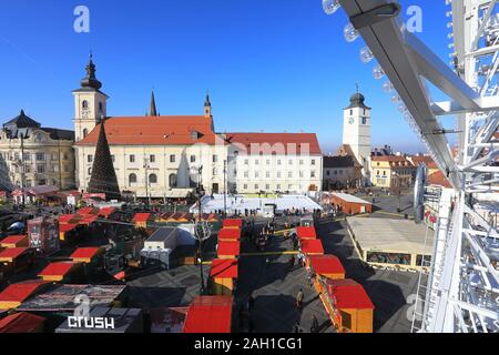 Vista da una grande ruota oltre il mercato di Natale nella Piata Mare a Sibiu in Transilvania, Romania Foto Stock