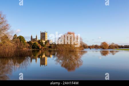 Tewkesbury Abbey attraverso il fiume Swilgate allagato in inverno, Inghilterra Foto Stock