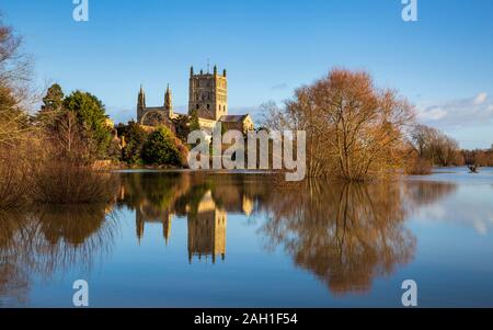 Tewkesbury Abbey attraverso il fiume Swilgate allagato in inverno, Inghilterra Foto Stock