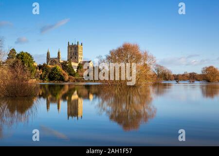 Tewkesbury Abbey attraverso il fiume Swilgate allagato in inverno, Inghilterra Foto Stock