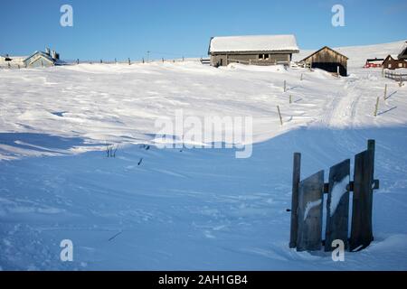 Vecchia cabina in legno, cottage in montagna con la neve in una giornata di sole Foto Stock