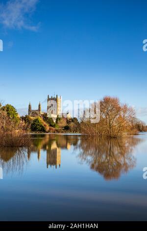 Tewkesbury Abbey attraverso il fiume Swilgate allagato in inverno, Inghilterra Foto Stock