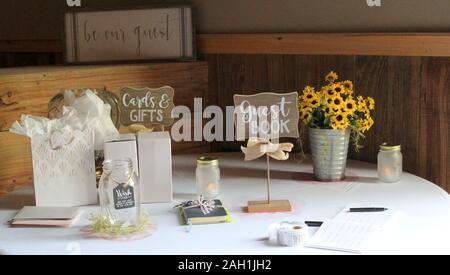 Un tavolo a un ricevimento di matrimonio con un guest book e un