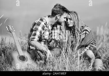 L'amore li ispira. Aria fresca e sentimenti puri. Escursionismo romance. Bella coppia romantica felice volti sorridenti sullo sfondo della natura. Ragazzo e ragazza con la chitarra. Passeggiata romantica. Canzone romantica. Foto Stock