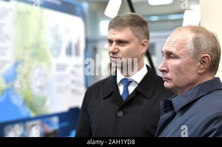 Taman, Russia. 23 dicembre, 2019. Le Ferrovie Russe CEO Oleg Belozerov, sinistra, descrive il progetto per il Presidente Vladimir Putin, a destra dopo la cerimonia di apertura per il ponte di Crimea - collegamento ferroviario attraverso la Stretto di Kerch collegamento di Crimea a Krasnodar Dicembre 23, 2019 in Taman, Russia. Il 19km ponte è il più lungo in Europa e fu completata cinque anni dopo la Russia annesse il Mar Nero penisola. Credito: Aleksey Nikolskyi Cremlino/Piscina/Alamy Live News Foto Stock