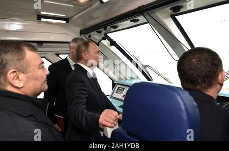 Taman, Russia. 23 dicembre, 2019. Il presidente russo Vladimir Putin sta nella prima carrozza del treno per attraversare il ponte di Crimea - collegamento ferroviario attraverso la Stretto di Kerch collegamento di Crimea a Krasnodar Dicembre 23, 2019 in Taman, Russia. Il 19km ponte è il più lungo in Europa e fu completata cinque anni dopo la Russia annesse il Mar Nero penisola. Credito: Aleksey Nikolskyi Cremlino/Piscina/Alamy Live News Foto Stock