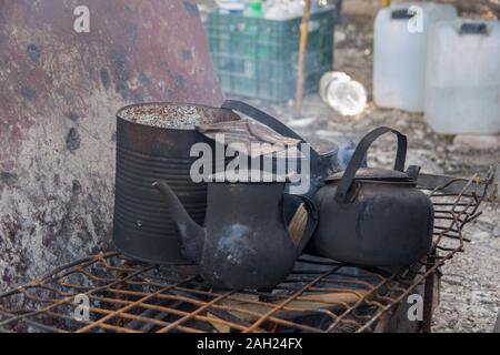 Metallo nero bollitori per caffè e un possibile, sul fuoco all'aperto posto in metallo nero bollitori per caffè e un possibile, sul fuoco all'aperto posto Foto Stock