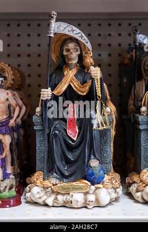 Santa Muerte statue in vendita presso El Kimbisero Botanica, un negozio sulla 37th Avenue Ave vendita di articoli religiosi di un principalmente un sud americana di popolazione. Foto Stock