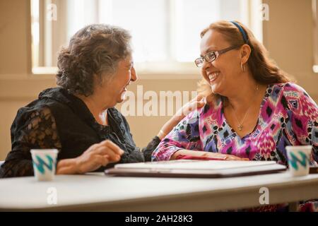 Due felici le donne anziane la riproduzione di un gioco di bordo insieme ad un tavolo. Foto Stock