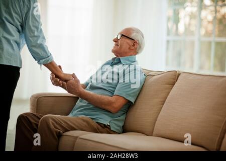 Sorridente uomo senior tenendo per mano di un irriconoscibile donna. Foto Stock