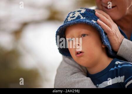 Ragazzo con la sua testa sul suo nonno lo spallamento Foto Stock