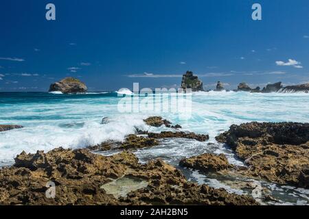 Delle onde dell'Oceano Atlantico crash sul calcare a riva della penisola di Pointe des Chateaux sull isola di Grande-Terre, Guadalupa. Foto Stock