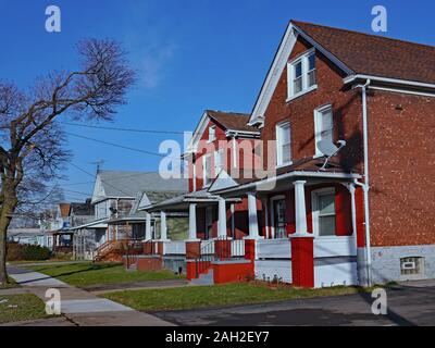 Strada di vecchie case unifamiliari con timpani e portici Foto Stock