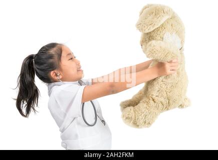 Carino bambino asiatico in medico umettare la riproduzione con Teddy bear in isolati background.education bianco e il concetto di occupazione Foto Stock