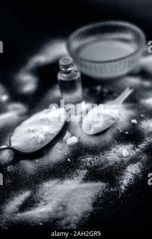Maschera per il viso o il viso pack di bicarbonato di sodio in un recipiente di vetro su una superficie di legno lungo con polvere e alcuni di olio di noce di cocco in un vetro trasparente bottiglia. Utilizzato per Foto Stock