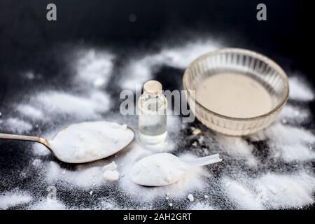 Maschera per il viso o il viso pack di bicarbonato di sodio in un recipiente di vetro su una superficie di legno lungo con polvere e alcuni di olio di noce di cocco in un vetro trasparente bottiglia. Utilizzato per Foto Stock