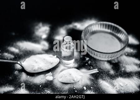 Maschera per il viso o il viso pack di bicarbonato di sodio in un recipiente di vetro su una superficie di legno lungo con polvere e alcuni di olio di noce di cocco in un vetro trasparente bottiglia. Utilizzato per Foto Stock