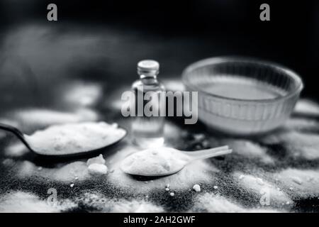 Maschera per il viso o il viso pack di bicarbonato di sodio in un recipiente di vetro su una superficie di legno lungo con polvere e alcuni di olio di noce di cocco in un vetro trasparente bottiglia. Utilizzato per Foto Stock