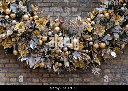 Enorme ghirlanda di Natale decorazione su una parete in Duke of York Square, Kings Road, a Chelsea, Londra, Regno Unito Foto Stock